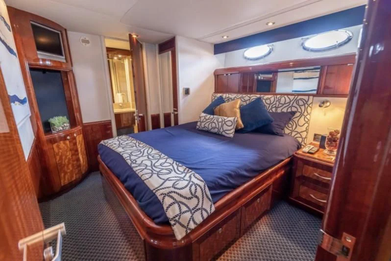 a bedroom with a bed and a dresser aboard CORAGGIO Yacht for Sale