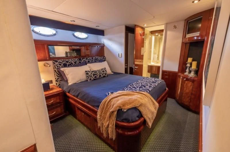 a bedroom with a bed and a dresser aboard CORAGGIO Yacht for Sale