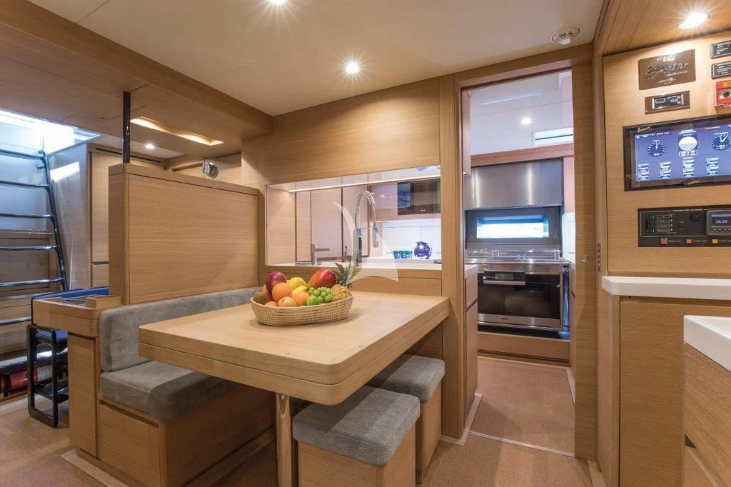 a kitchen with a table and chairs aboard KIWAYU Yacht for Charter
