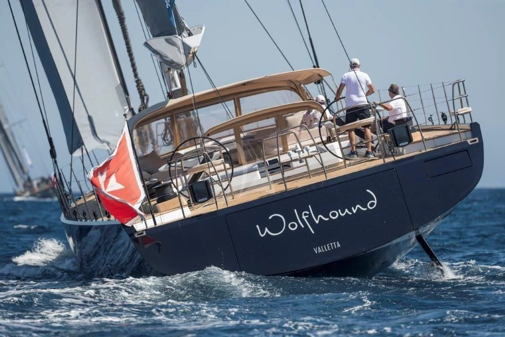 a boat with a red sail aboard KIWAYU Yacht for Charter