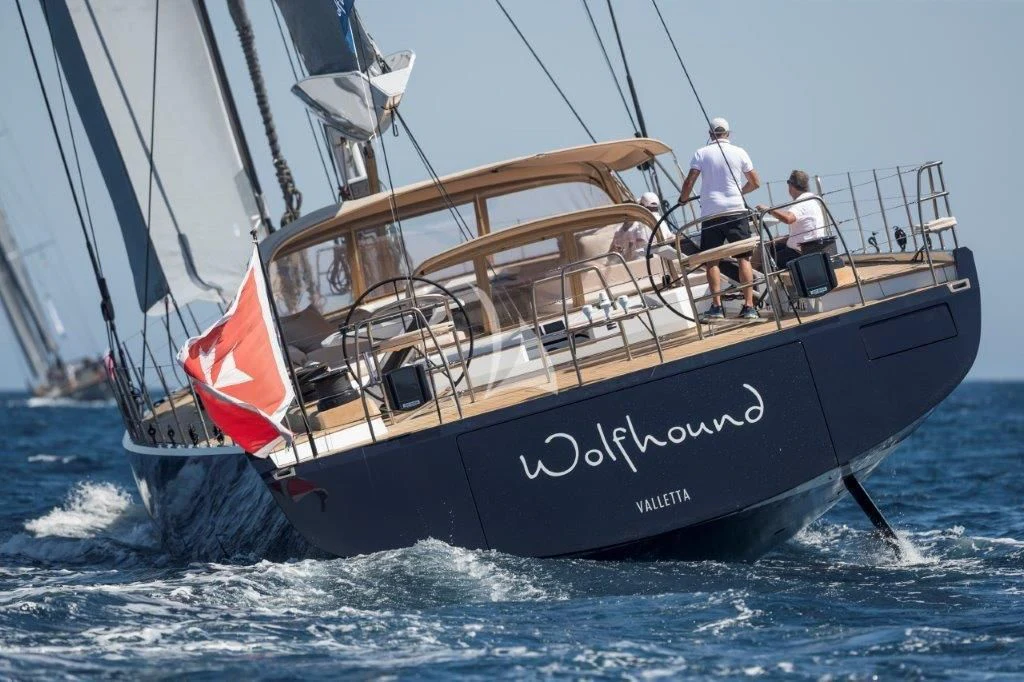 a boat with a red sail aboard KIWAYU Yacht for Charter