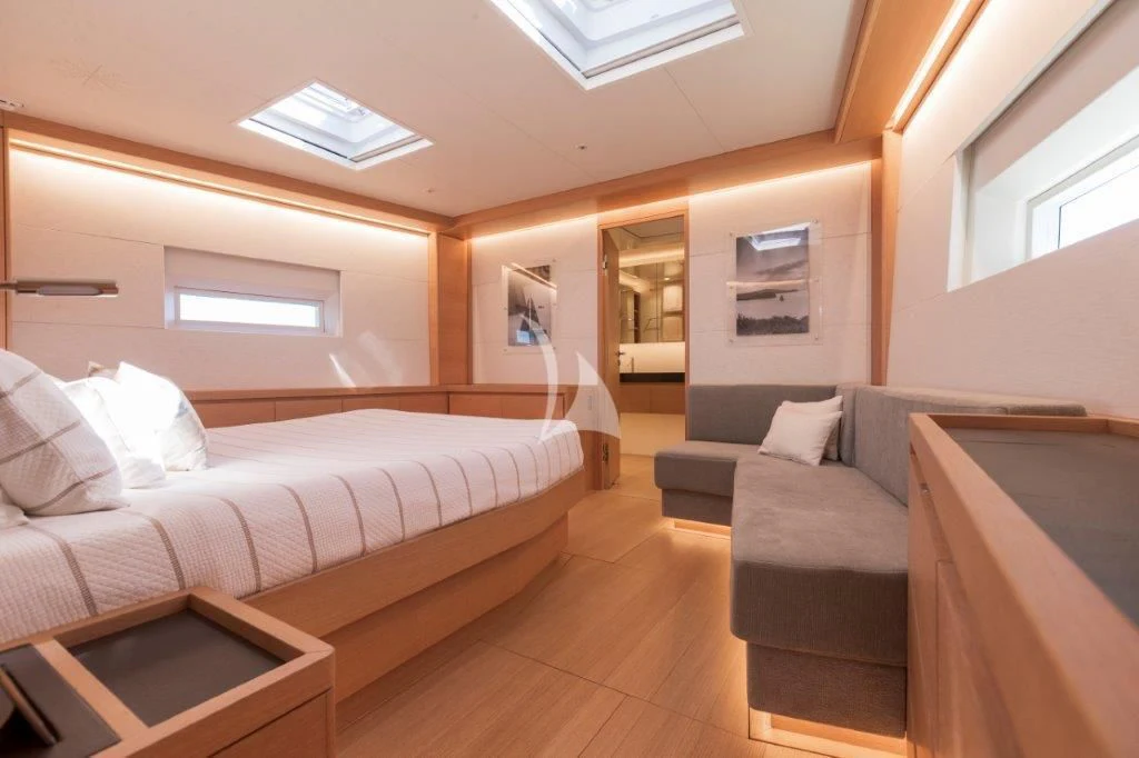 a room with a bed and a couch aboard KIWAYU Yacht for Charter