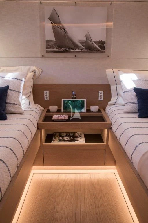 a bed with a table and a television on it aboard KIWAYU Yacht for Charter
