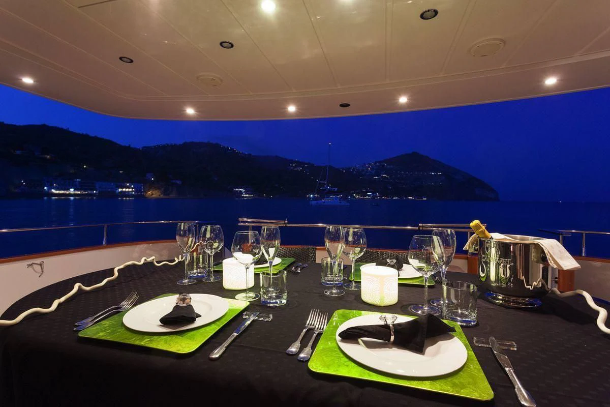 a table with plates and glasses on it aboard WHITEHAVEN Yacht for Sale