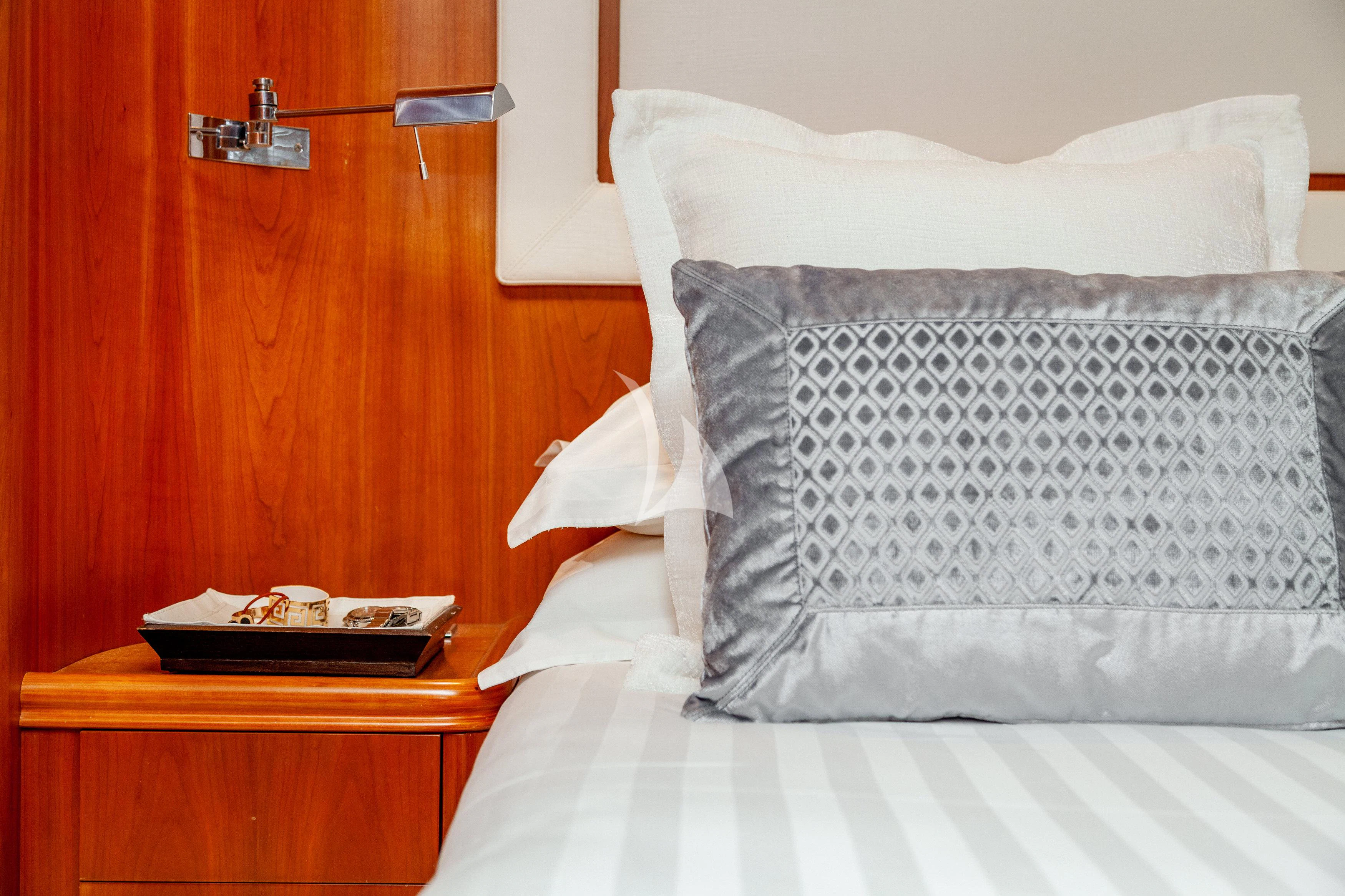 a bed with a pillow and a book on it aboard WHITEHAVEN Yacht for Sale