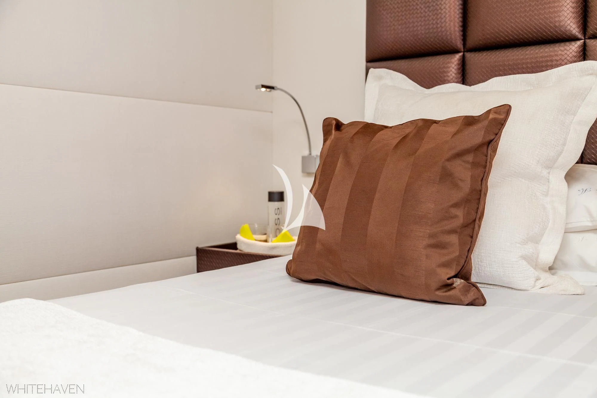 a bed with pillows and a lamp aboard WHITEHAVEN Yacht for Sale