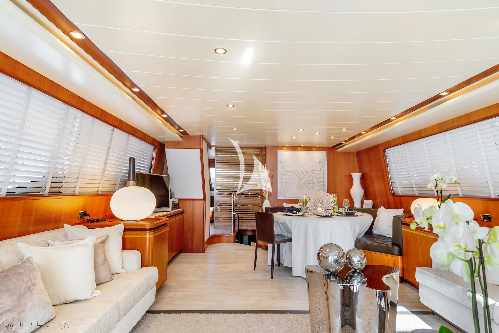a large living room with a dining table and chairs aboard WHITEHAVEN Yacht for Sale
