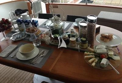 a table with plates and cups of food on it aboard WHITEHAVEN Yacht for Sale