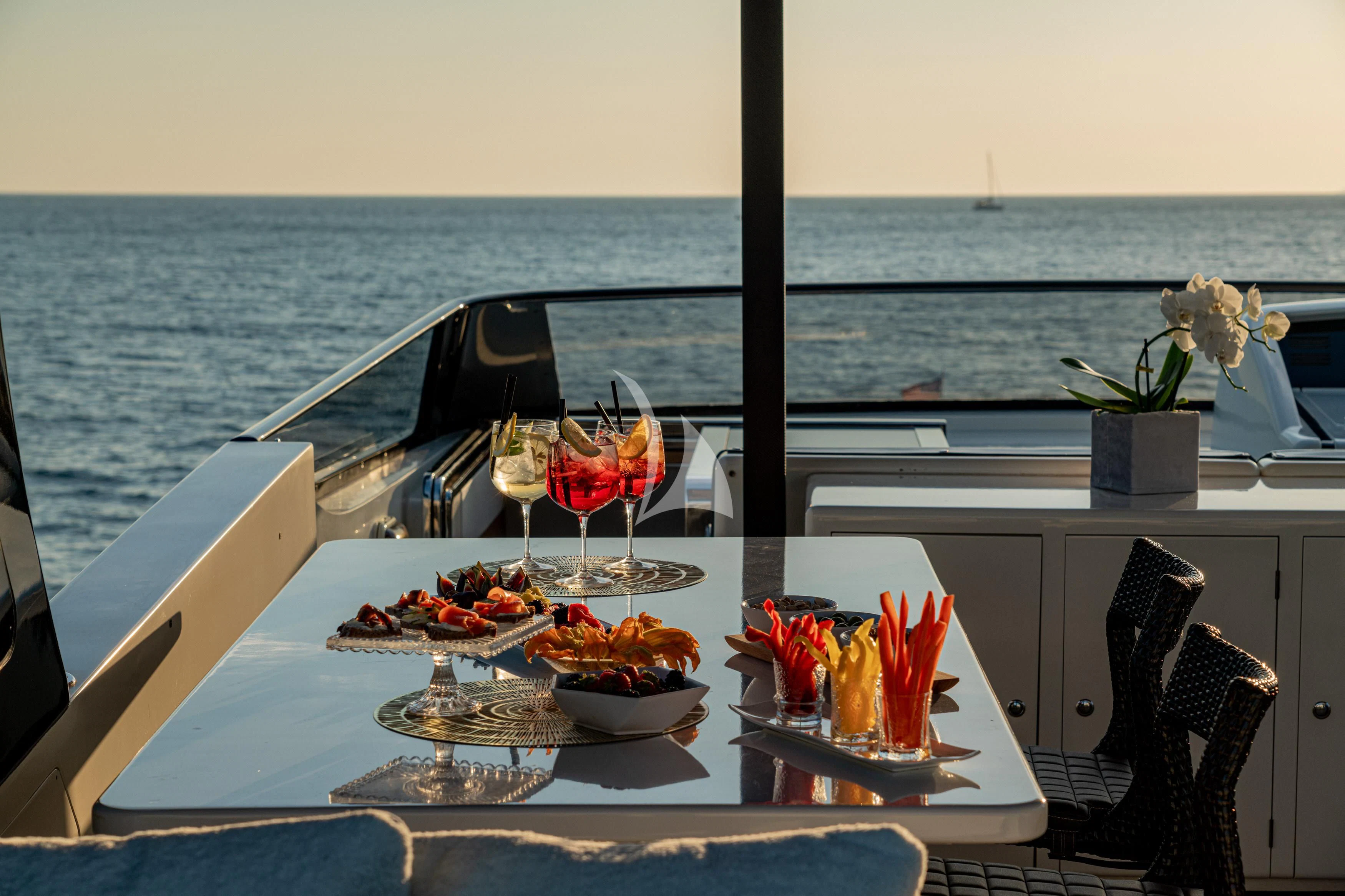 a table with food and drinks on it by the ocean aboard WHITEHAVEN Yacht for Sale