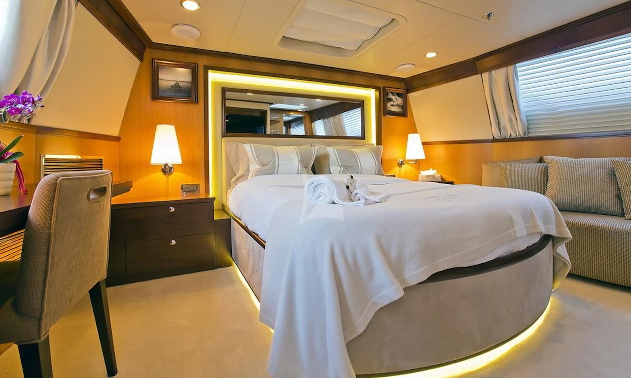 a hotel room with a bed and a couch aboard XO OF THE SEAS Yacht for Sale