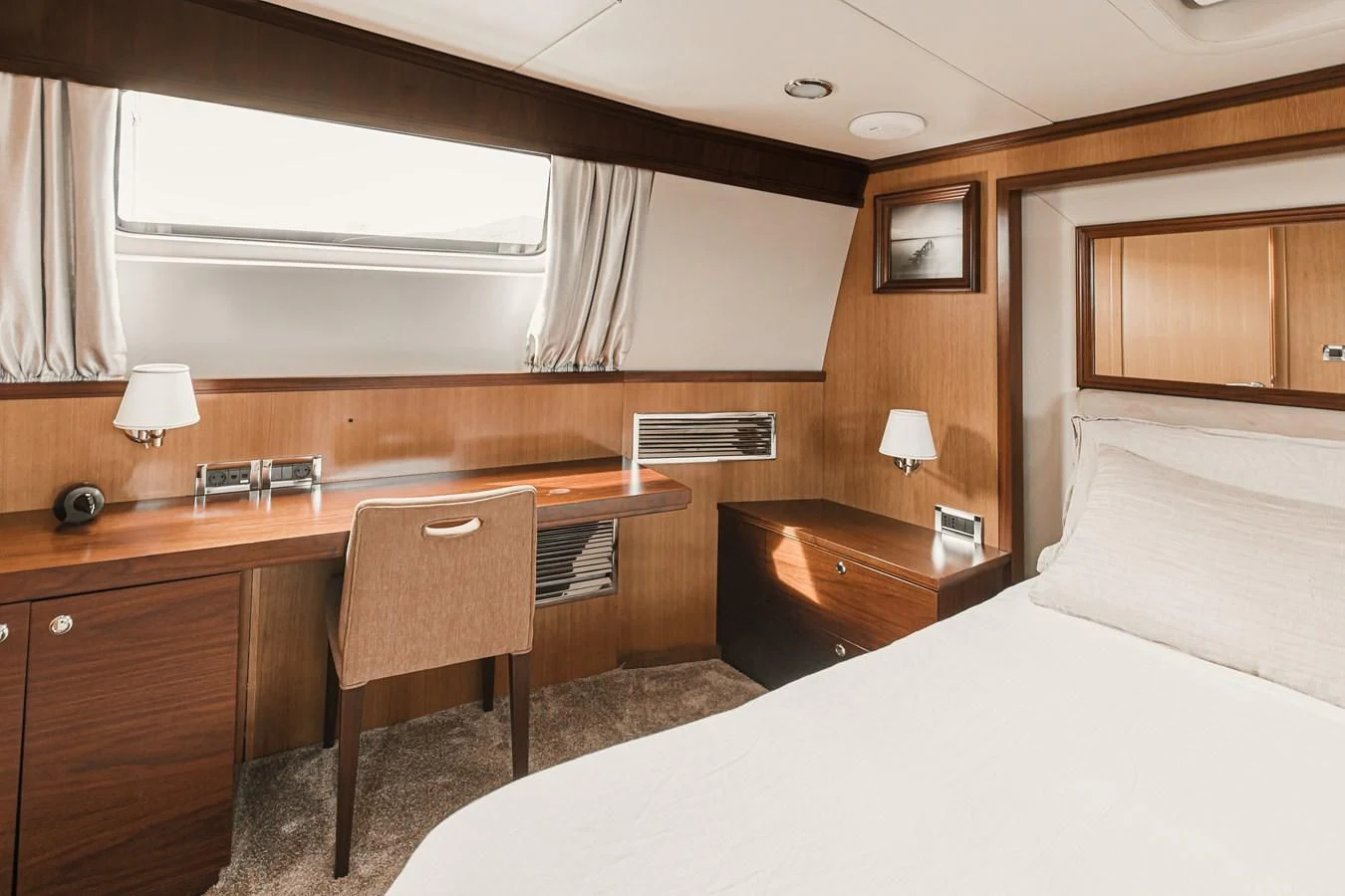 a bedroom with a desk and a bed aboard XO OF THE SEAS Yacht for Sale