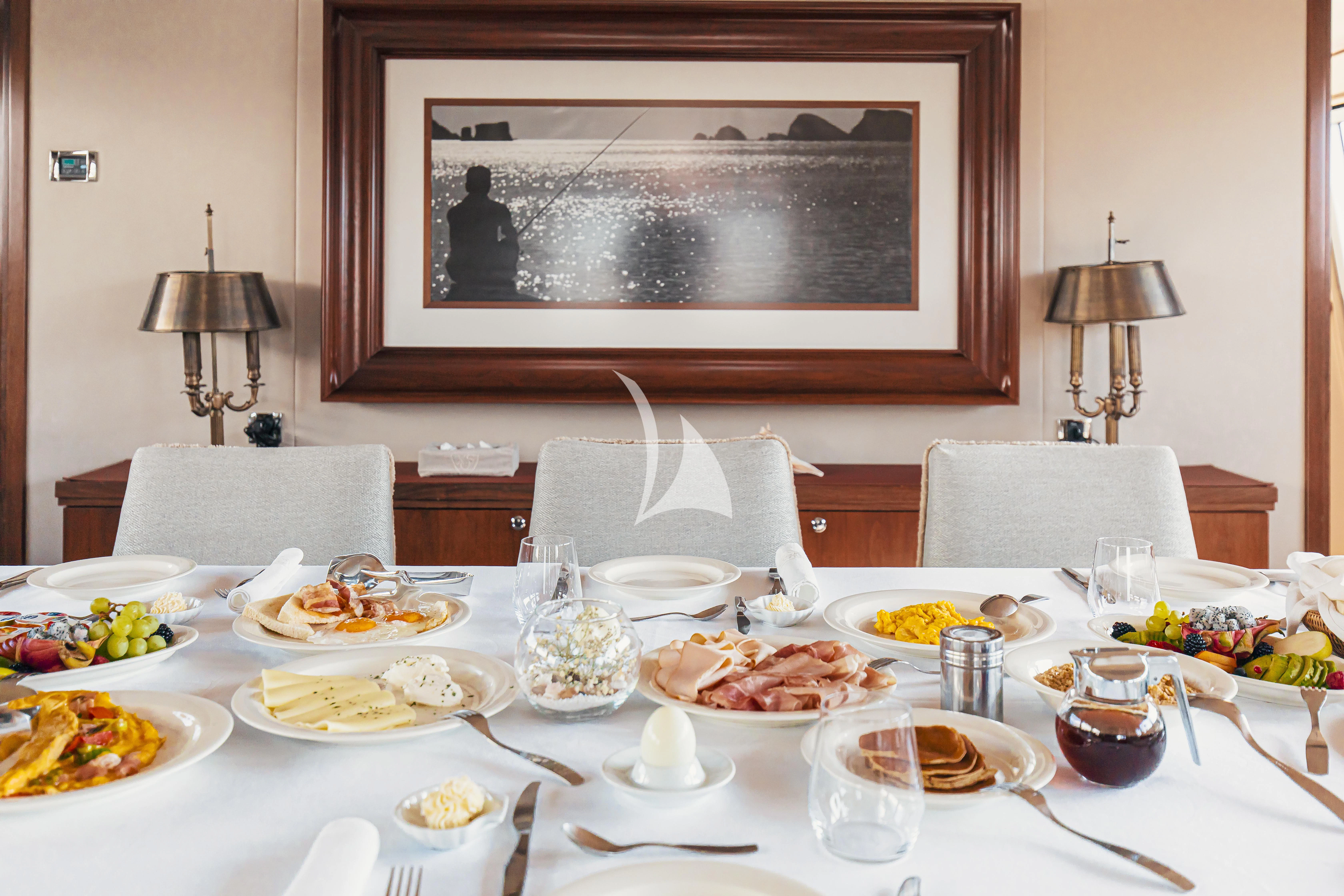 a table with plates and food on it aboard XO OF THE SEAS Yacht for Sale