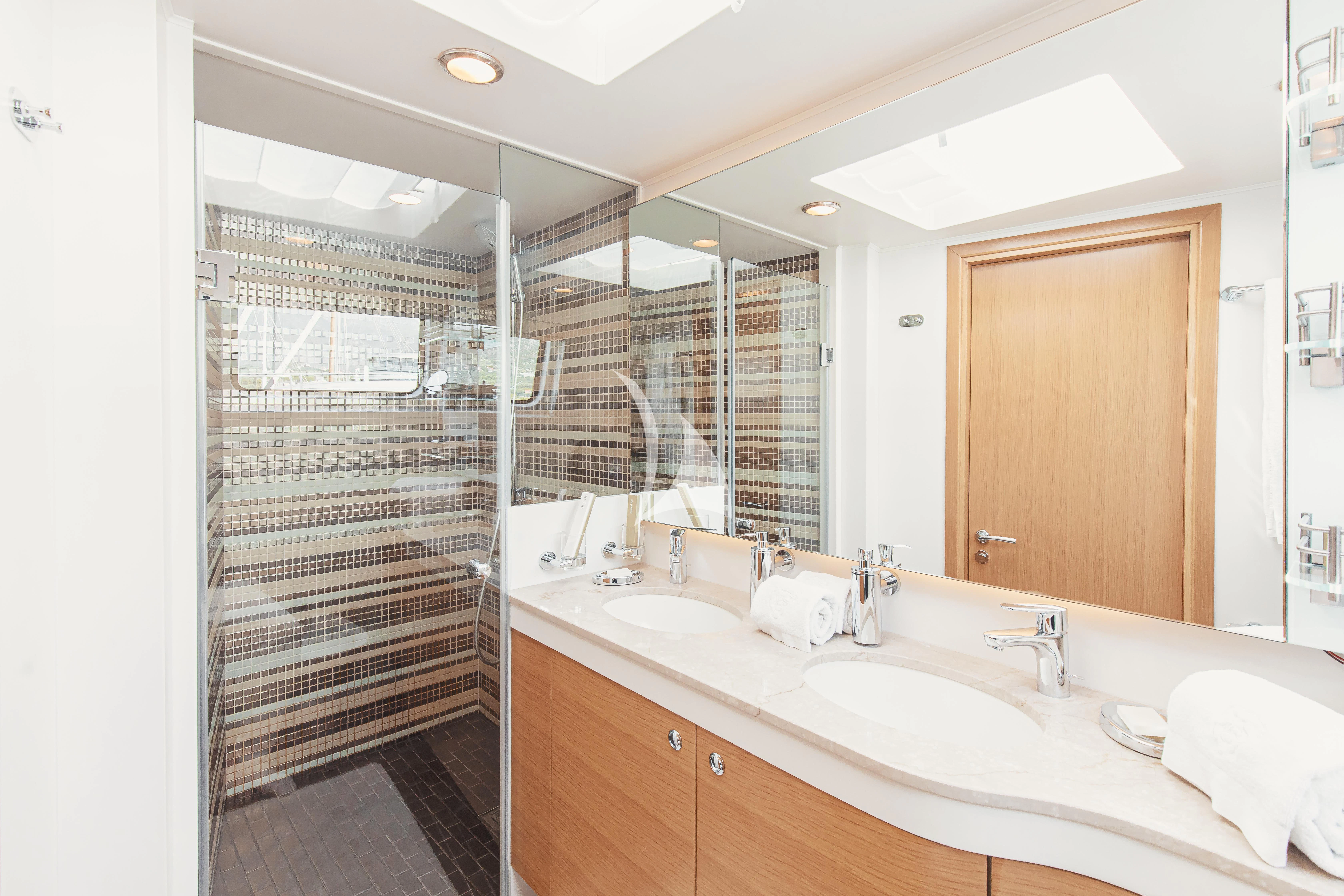 a bathroom with a sink and a shower unit aboard XO OF THE SEAS Yacht for Sale