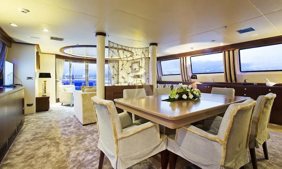 a large room with a table and chairs aboard XO OF THE SEAS Yacht for Sale