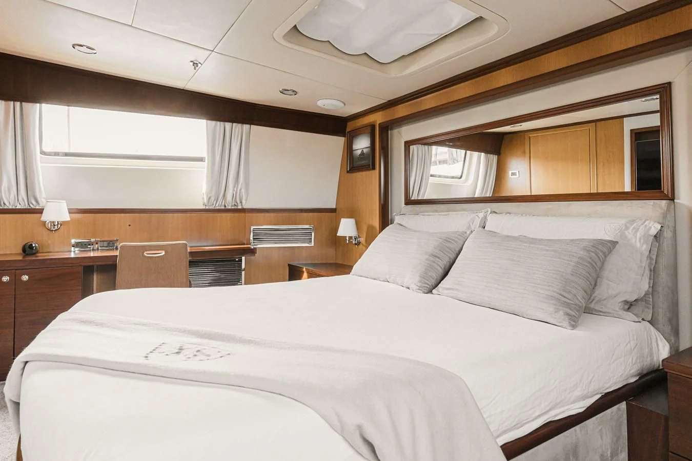 a bedroom with a bed and desk aboard XO OF THE SEAS Yacht for Sale
