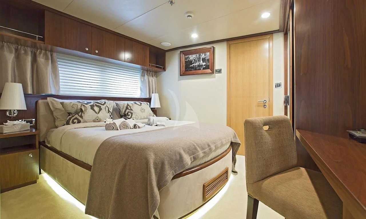 a bedroom with a bed and a chair aboard XO OF THE SEAS Yacht for Sale