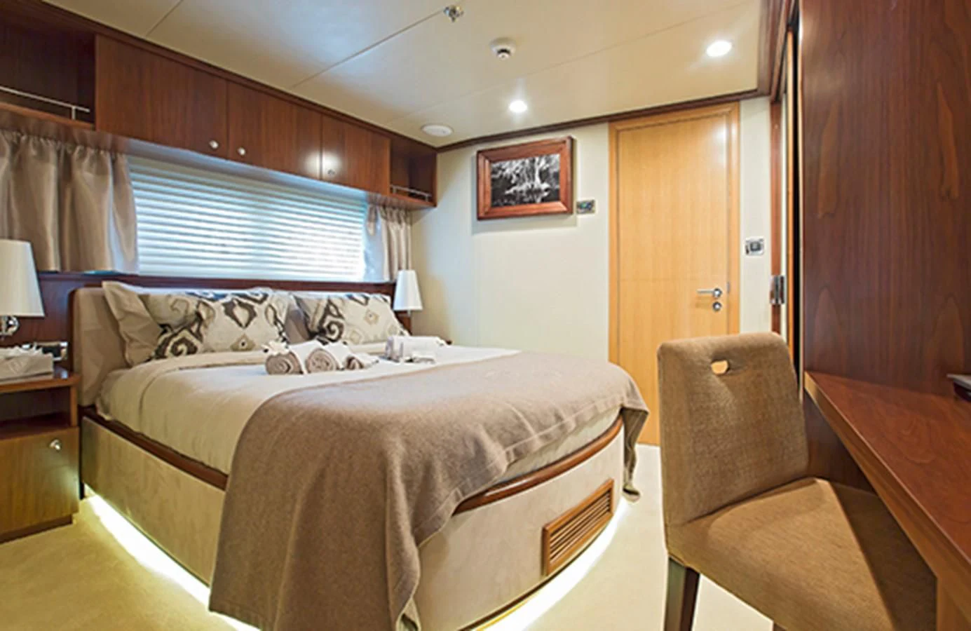 a bedroom with a bed and a chair aboard XO OF THE SEAS Yacht for Sale