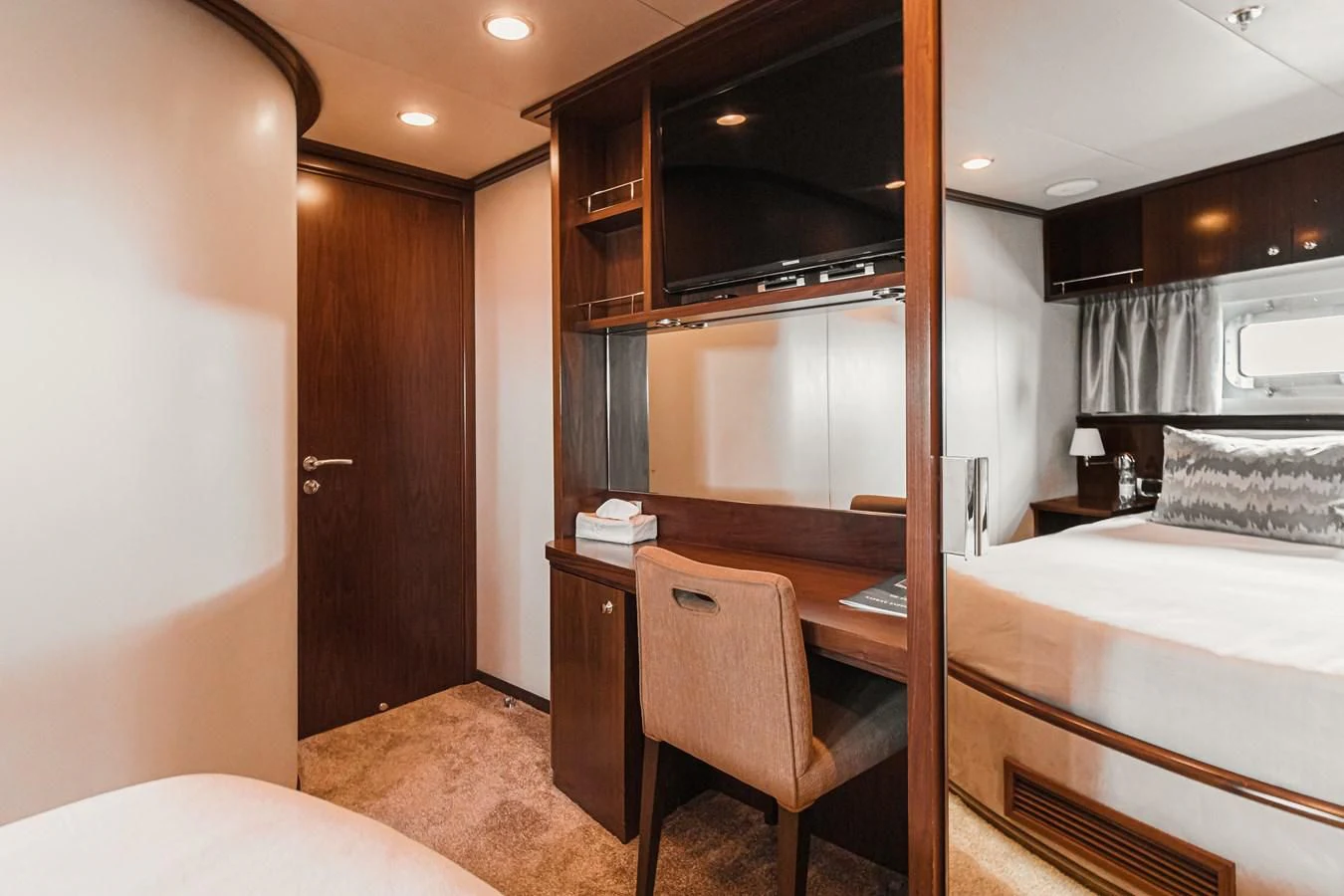 a room with a desk and a bed aboard XO OF THE SEAS Yacht for Sale