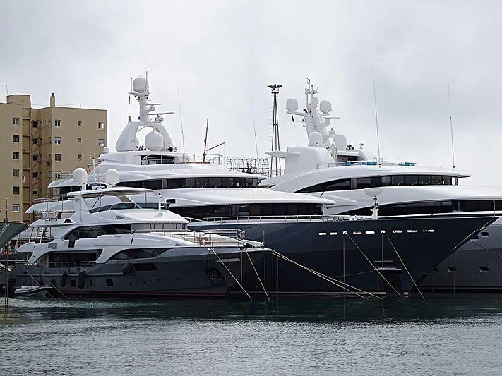 a couple of large white boats in the water aboard TITAN Yacht for Sale