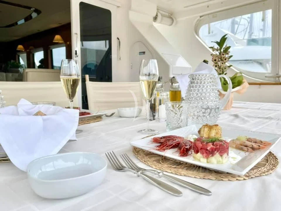 a table with plates of food and glasses on it aboard SHANGRA Yacht for Sale