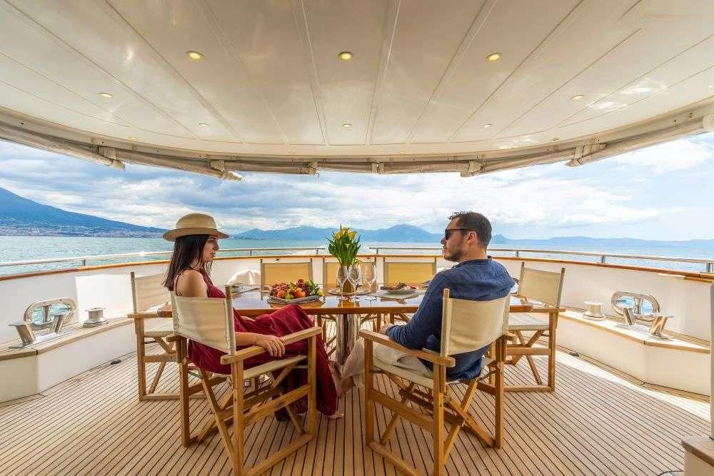 a couple sitting at a table on a boat aboard SHANGRA Yacht for Sale