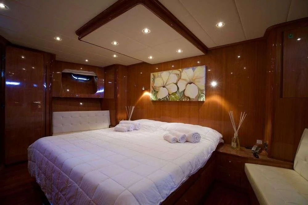 a bedroom with a bed and a wood wall aboard SHANGRA Yacht for Sale