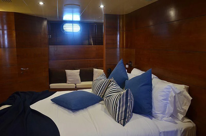 a bed with blue pillows aboard FIORENTE Yacht for Sale