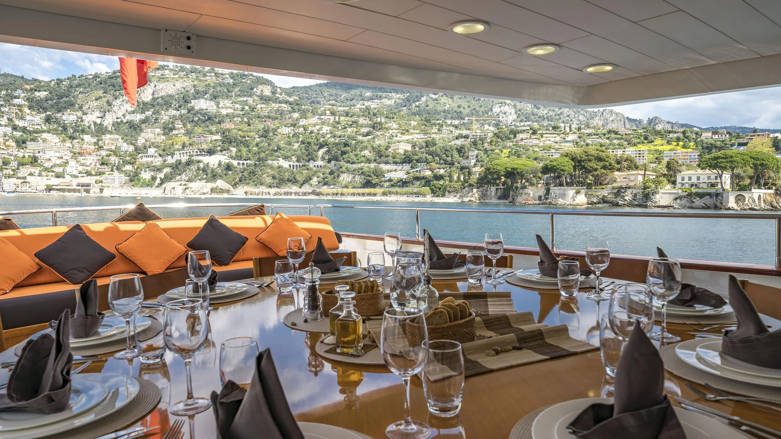 a table with wine glasses and a view of a city aboard FIORENTE Yacht for Sale