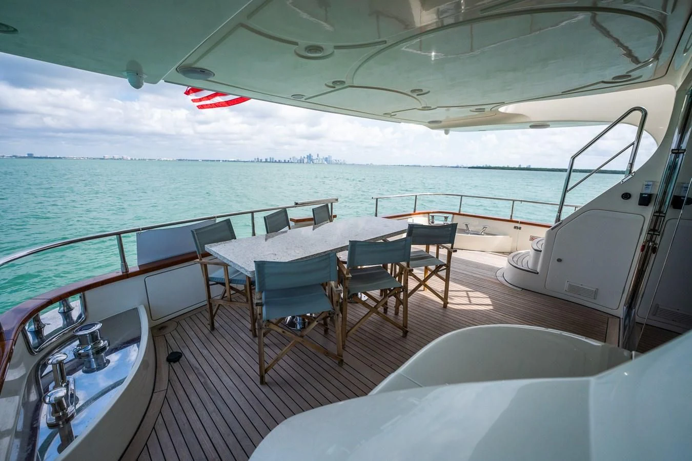 a deck with a table and chairs on it aboard 80 CARAT Yacht for Sale