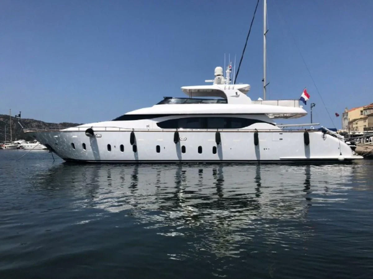 a white boat in a harbor aboard GULU Yacht for Sale