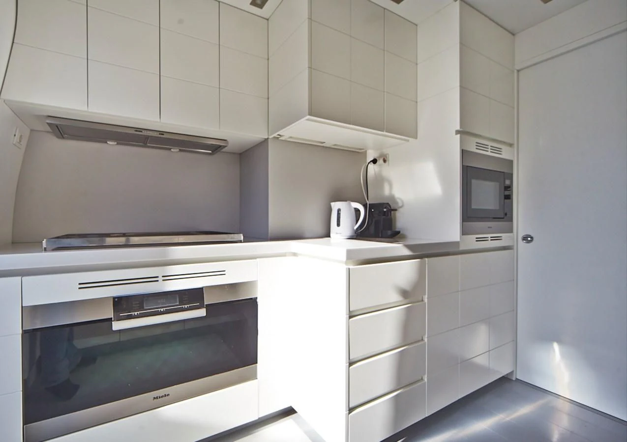 a kitchen with white cabinets aboard GULU Yacht for Sale