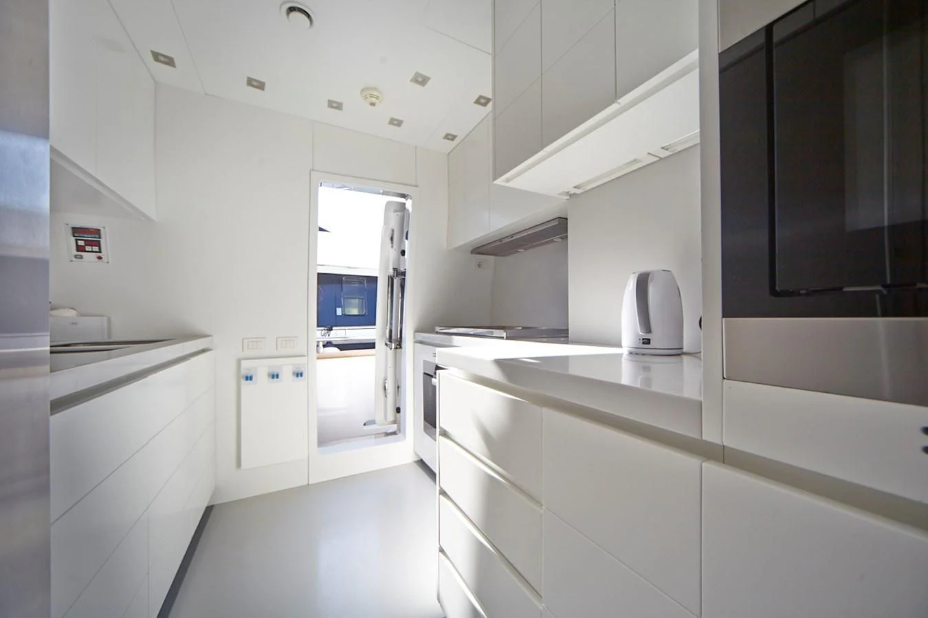 a white kitchen with black cabinets aboard GULU Yacht for Sale