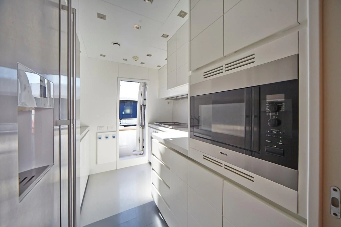 a kitchen with white cabinets aboard GULU Yacht for Sale