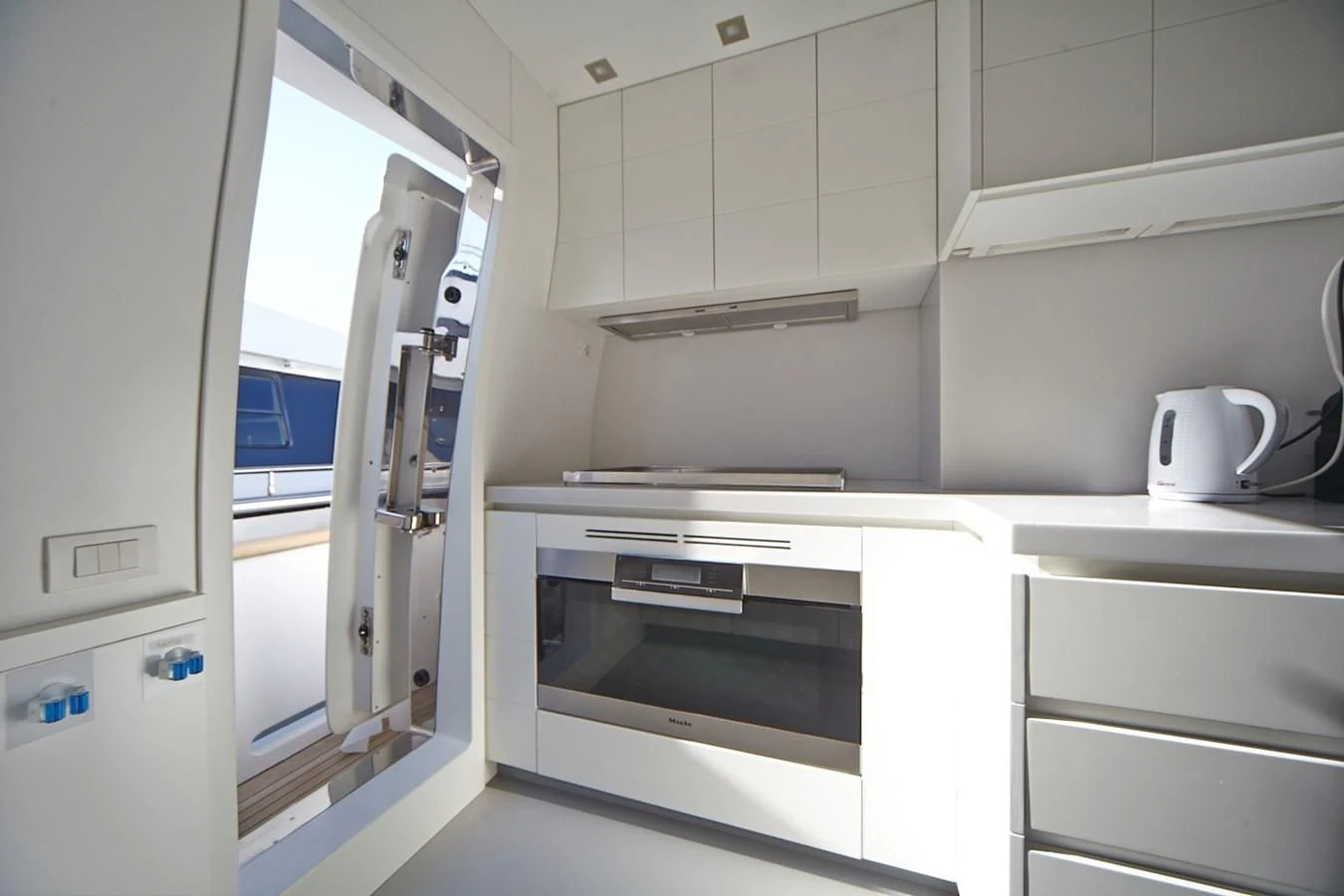 a kitchen with a white microwave and cabinets aboard GULU Yacht for Sale