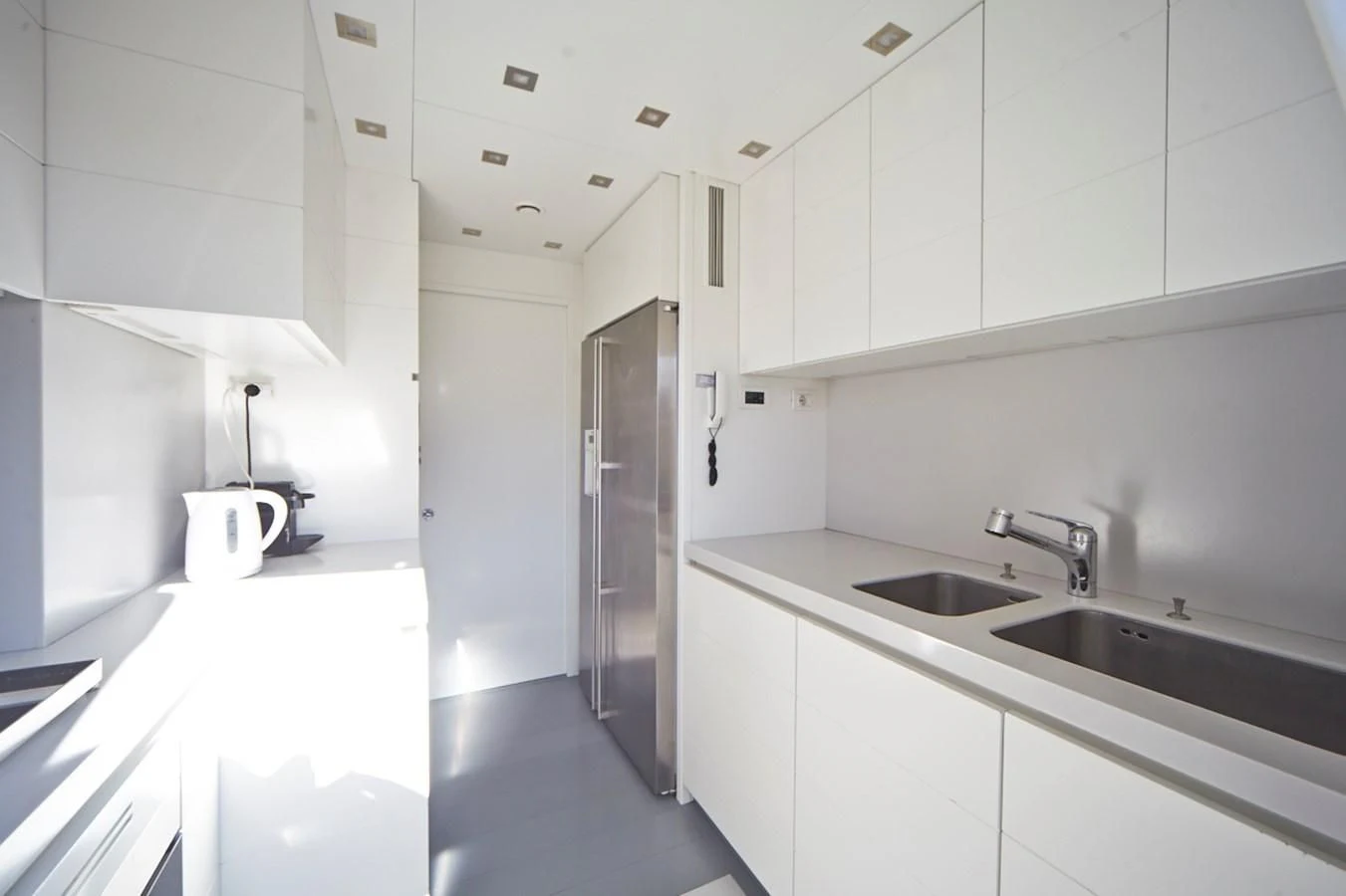 a kitchen with white cabinets aboard GULU Yacht for Sale