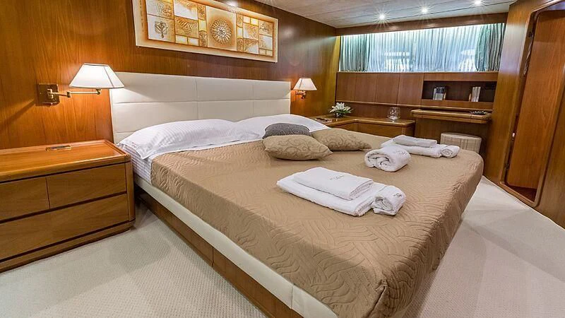 a room with a bed and a dresser aboard PIERPAOLO IV Yacht for Sale