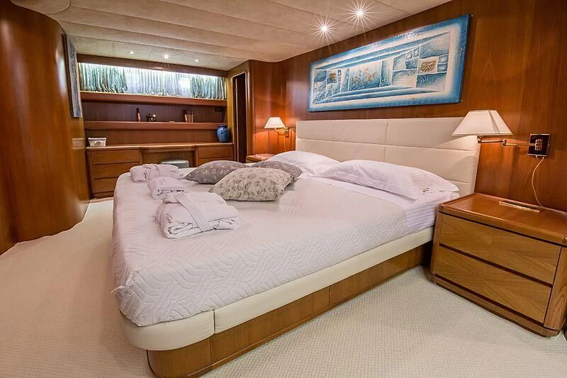 a bedroom with a bed and a dresser aboard PIERPAOLO IV Yacht for Sale