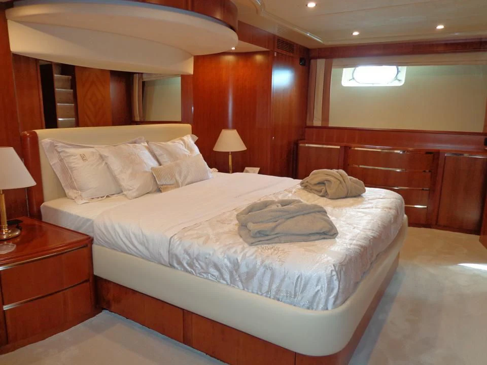 a bed with a white comforter aboard MARACANA Yacht for Sale