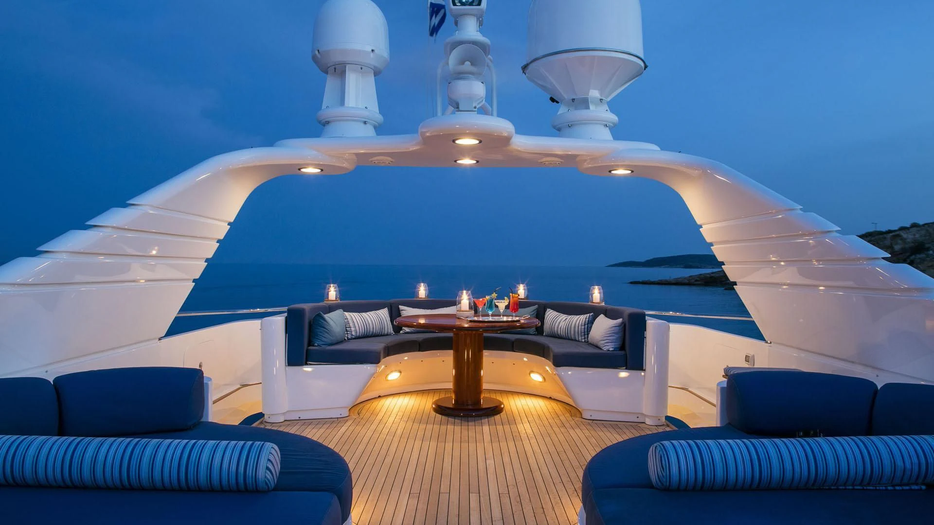 a large room with a large blue wall and a large white bed with a round table and a aboard JAAN Yacht for Sale