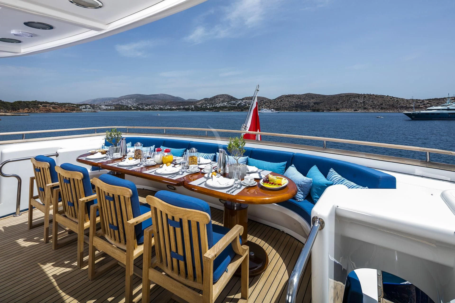 a table set for a meal on a deck overlooking the ocean aboard JAAN Yacht for Sale