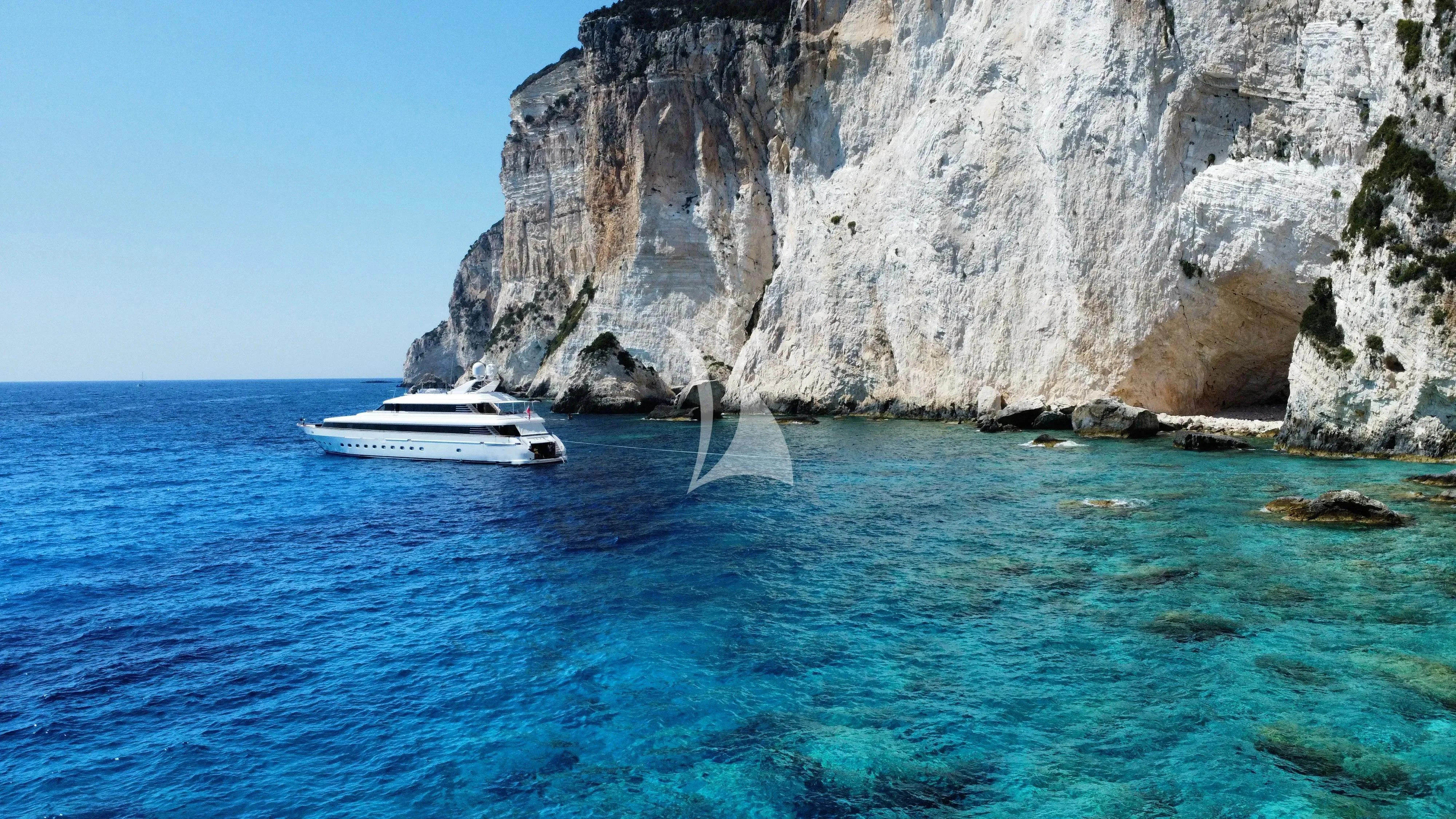 a boat in the water by a cliff aboard JAAN Yacht for Sale