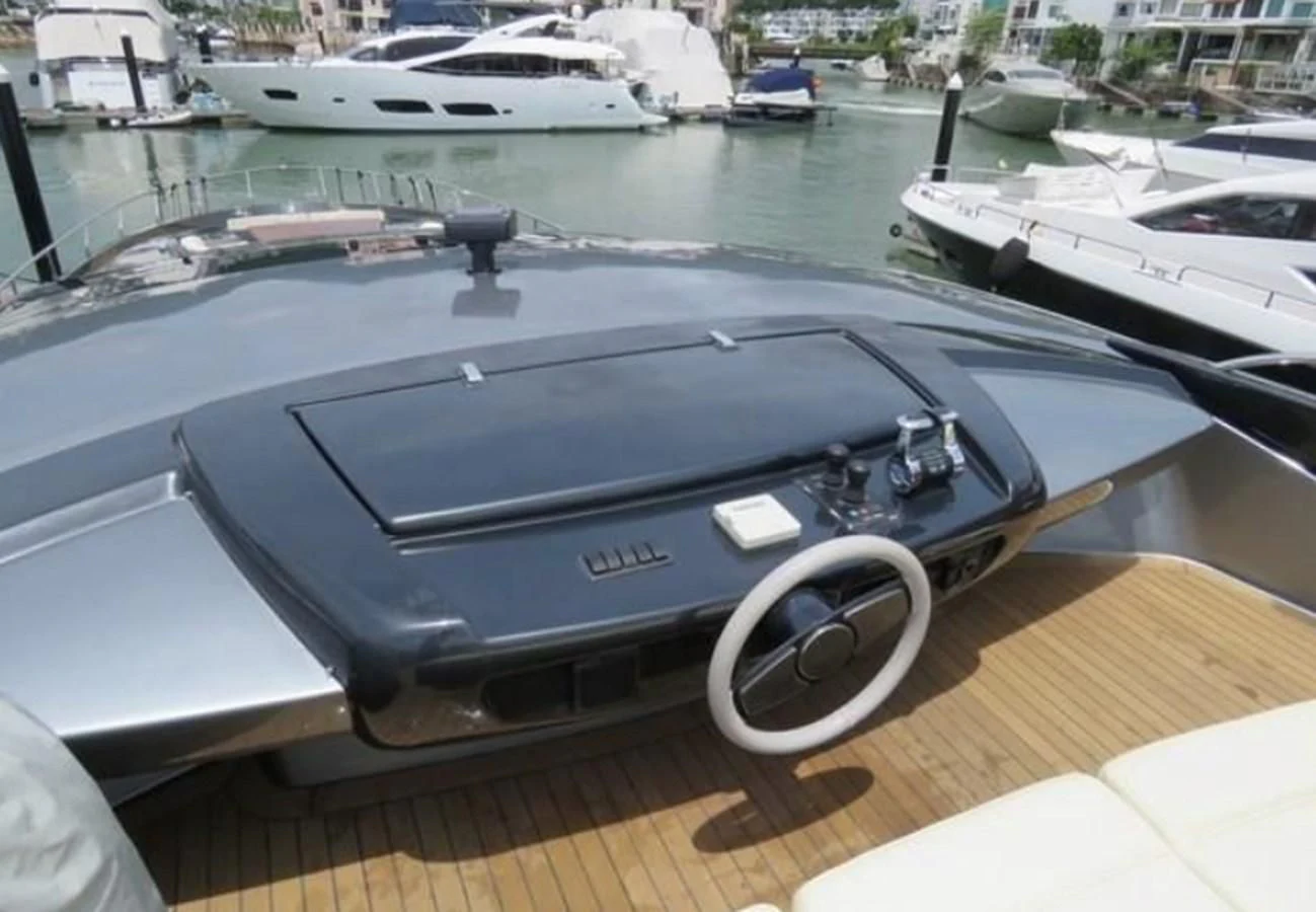 a black convertible car parked on a dock next to a marina aboard RIVA 86 DOMINO Yacht for Sale