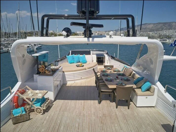 a deck with a table and chairs on it aboard SANSARA Yacht for Sale