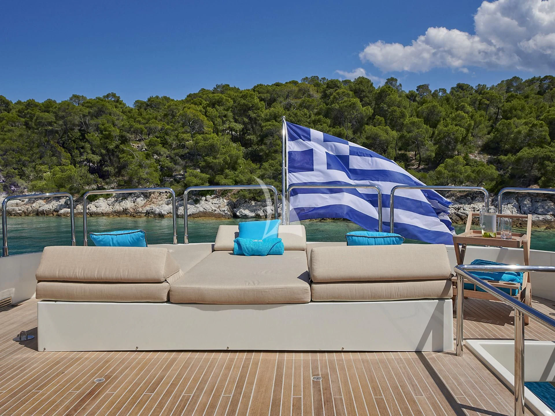 a lounge chair on a deck overlooking a body of water aboard SANSARA Yacht for Sale