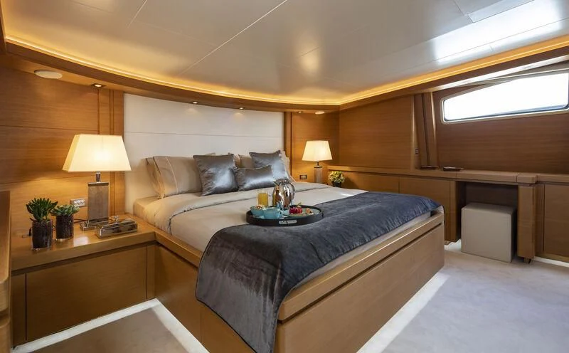 a bedroom with a bed and a desk aboard SANSARA Yacht for Sale