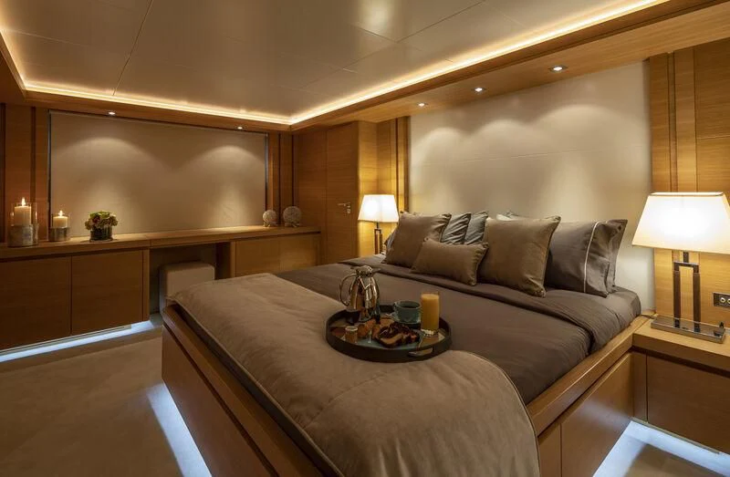a bed with a table and lamps aboard SANSARA Yacht for Sale