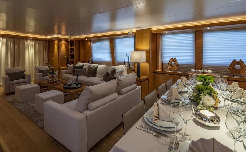 a living room with a large white table and white couches aboard SANSARA Yacht for Sale