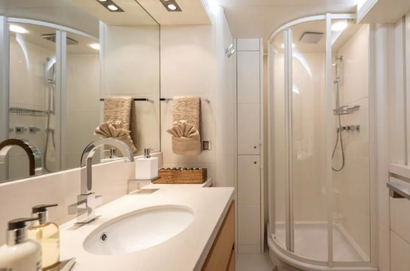 a bathroom with a shower sink and mirror aboard SANSARA Yacht for Sale