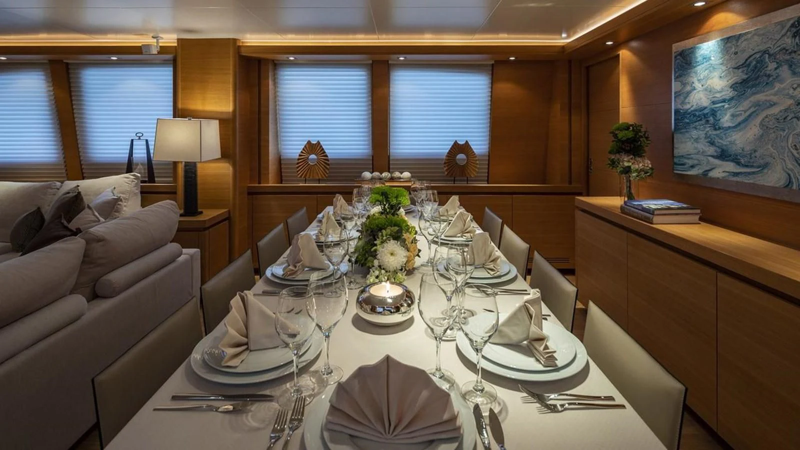 a dining table set with plates and flowers aboard SANSARA Yacht for Sale