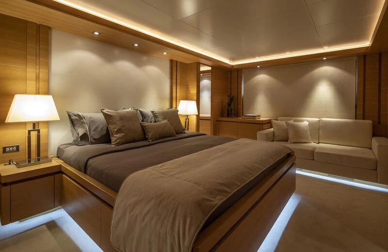 a hotel room with a bed and a couch aboard SANSARA Yacht for Sale